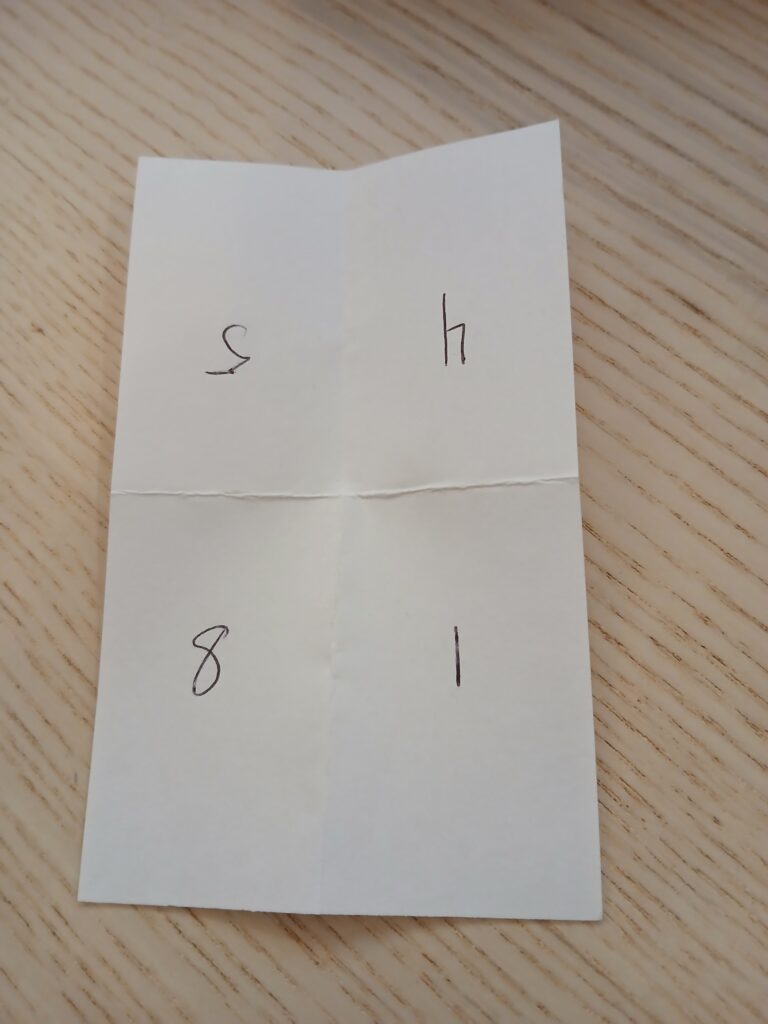 Photo of an index card that's been folded in half twice, to create four sections. In clockwise order, the numbers are 5, 4, 1, and 8. 5 and 4 are upside down.